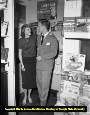 Record store couple listens to a selection of vinyl records, 1951
