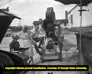 Production crew and actress looks over script before filming, circa 1940s