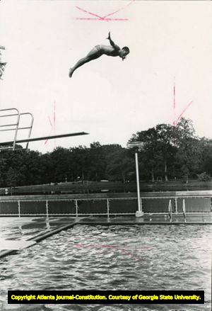 Young African American boy diving off board into pool, Piedmont Park, Atlanta, Georgia, September 1978.