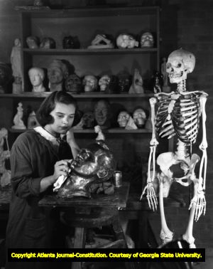 Art student sculpts and polishes a bust, 1950