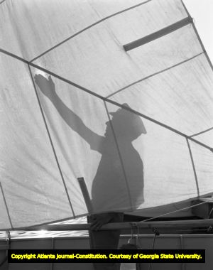 Silhouette of a man fixing his boat's sail, 1950