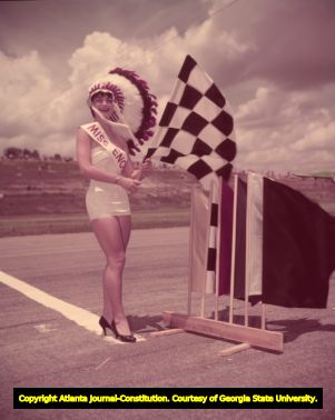 Miss Enoche on the racetrack as the checkered flag girl, 1957