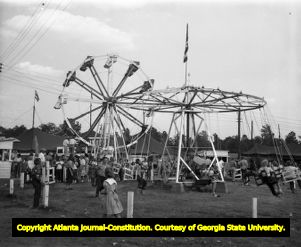 Small town carnival with a ferris wheel and swings, circa 1940s
