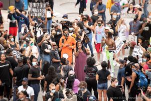 A woman uses a bullhorn to speak to protesters