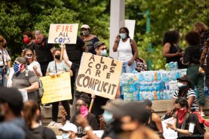 Protesters gather together holding up signs as they begin to protest