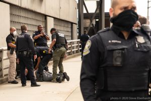 Police Officers arrest a man at the protest