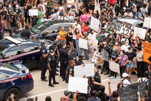 Protesters and Officers stand in a line facing each other