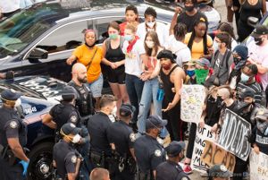A protester begins to speak to police officers who were blocking off the road