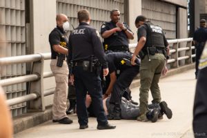 Police Officers arrest a man at the protest
