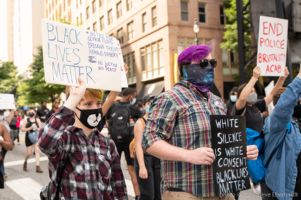 Two protesters march through the streets holding signs in the air
