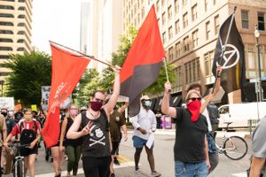 Protesters march through the streets holding flags in the air