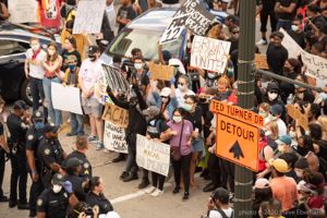 Protesters and Officers stand in a line facing each other