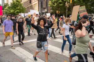 A protester marches with their arms held in the air