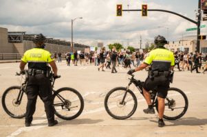 Police Officers stand in the middle of an intersection, rerouting protesters
