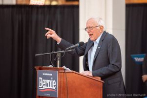 Bernie Sanders points towards the crowd while giving a speech