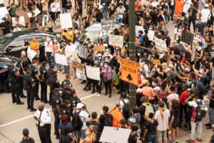 Protesters and Officers stand in a line facing each other