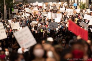 Protesters fill up the street as they hold a multitude of signs and banners in the air