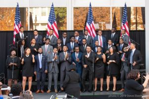 A group of students clap and sing