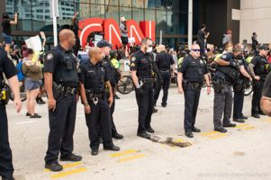 Officers stand in a straight line in the middle of the street