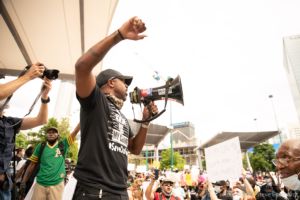 Marcus Coleman uses a bullhorn to speak to other protesters in the crowd