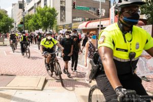 Police Officers ride alongside protesters on bikes as they protesters continue their protest