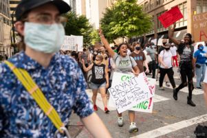 Protesters march through the streets chanting and holding signs and fists in the air