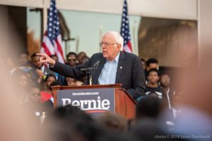 Bernie Sanders points at the crowd while speaking to them