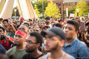 Protesters gather together as they listen to a speech being made