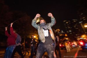 A protester marches through the streets holding up two fists up