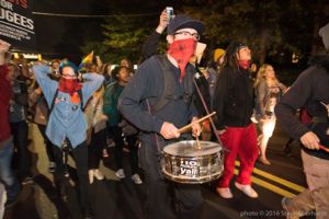 A protester marches through the streets playing a drum