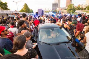 Protesters surrounding car as they continue their protest