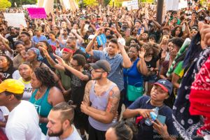 Protesters gather together as they listen to a speech being made