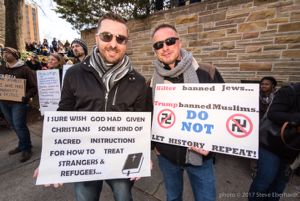 Two protesters hold up sign as they protest together