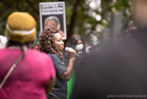 Monica Robinson uses a microphone to give a speech
