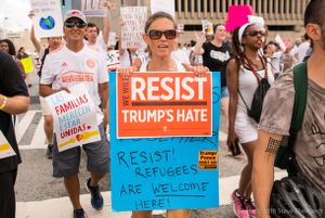 A protester holds up a sign reading 'We Will Resist Trump's Hate'