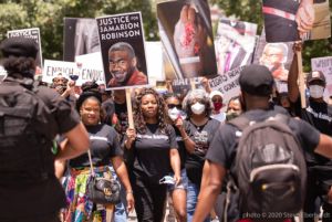Protesters march through the streets holding signs in the air