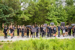 Protesters stand along the Beltline in a line with raised fists and signs