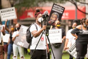 A protester records the protest using their camera