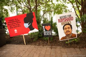 Signs stuck in the ground talk about COVID-19 and Black Lives Matter