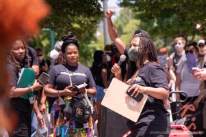 A protester uses a microphone to speak to gathered protesters before the march