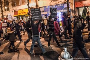 Protesters march through downtown Atlanta holding a glowing Black Lives Matter sign
