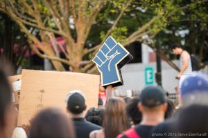 A Black Lives Matter fist symbol is held up in the protester crowd
