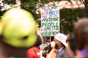 A protester in Woodruff Park holds up a large sign