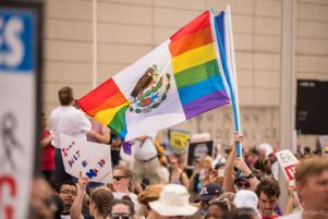 A protester waves flags over the crowd as they gather together