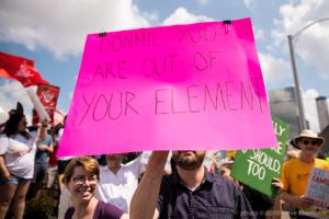 A protester holds up a pink sign reading 'Donnie you are out of your element'