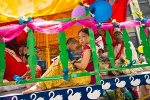 Children dressed in traditional clothing sit on the cart