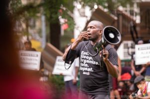 A male protester uses a bullhorn to speak to gathered in Woodruff Park