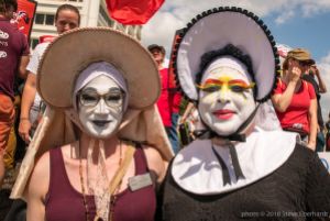 Two protesters stand together with painted faces