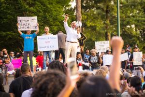 Mawuli Davis gives a speech while holding up his fist