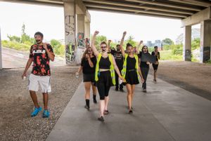 Protesters with raised fists march underneath a bridge along the Beltline